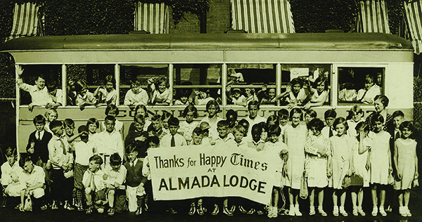 Children pose in front of a trolley car at the Times Country Camp